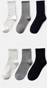 Detail of white, grey, and black cotton crew socks showcasing ribbing and knit texture