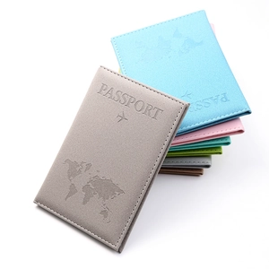 Close-up of stacked matte PU leather passport covers featuring world map embossed detail