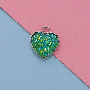 Macro shot of 13mm heart pendant with green glitter filling and polished silver frame
