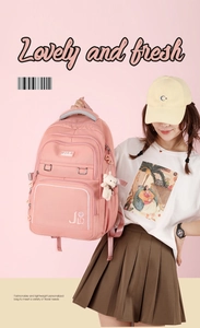 Close-up of pink nylon backpack with cute bear pendant and spacious front compartments