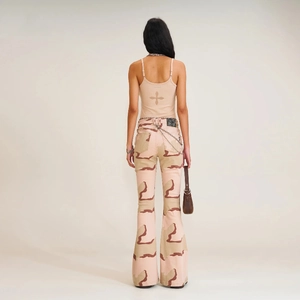 Rückansicht der rosa Camouflage-Schlagjeans mit Kreuz-Detail und Metallketten-Accessoire