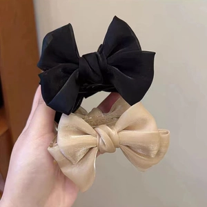 Detail showing high-quality organza texture of black and champagne bow hair clips