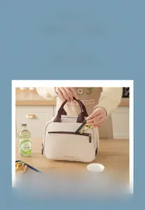 Detail of insulated lunch bag with front zipper pocket for utensils and top handles