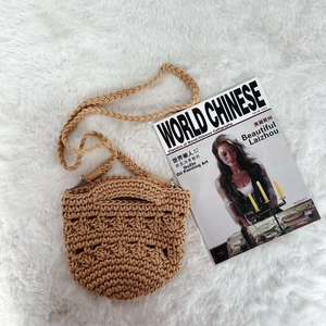 Handmade crochet cotton shoulder bag with woven pattern on a white fur rug
