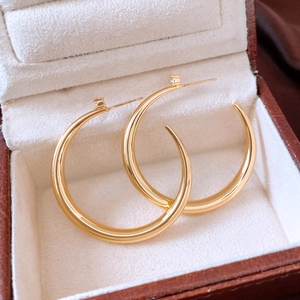 Detailed view of 18k gold plated hoop earrings displayed in a luxury jewelry box