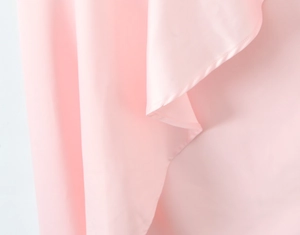 Detail of pink silky fabric with high drape and refined edge stitching for formal dress