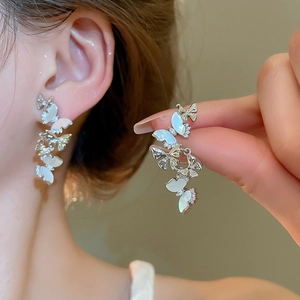 Detailed view of silver butterfly tassel earrings with mother of pearl and zircons