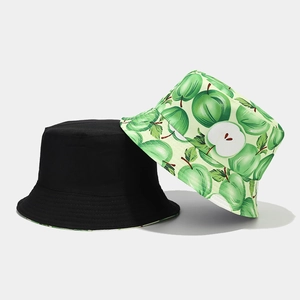 Reversible bucket hat with black solid side and green apple print design