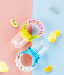 Macro view of silicone baby fruit feeder with rattling handle and colorful fruit slices