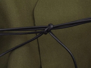 Close-up of olive green knit fabric texture with a slim black faux leather waist tie knot