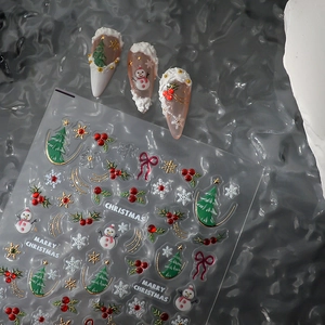 Détail d'autocollants 5D pour ongles de Noël avec bonhommes de neige et nœuds d'or