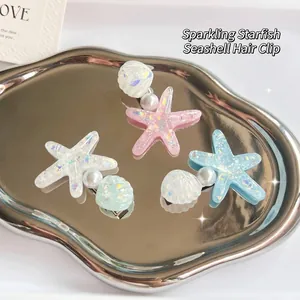 Dreamy glitter starfish and shell hair clips with pearls on a silver mirror tray