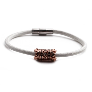 Detail of white leather braided bracelet with rose gold zircon bead and magnetic clasp