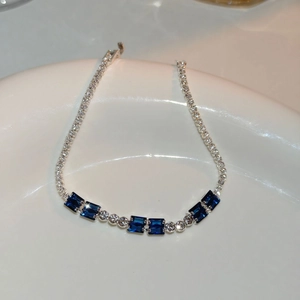 Close-up of a silver bracelet featuring vibrant rectangular blue stones and pavé zircon details