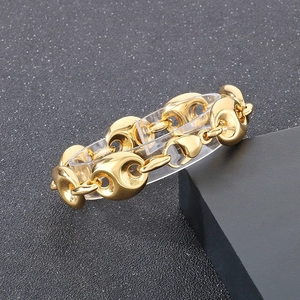Macro shot of 18k gold plated coffee bean link chain bracelet on a clear display stand