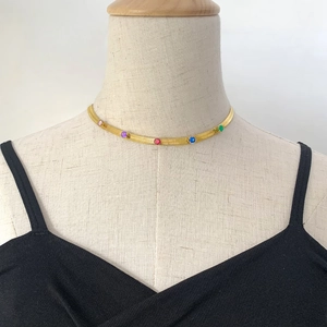 Golden snake chain necklace with multicolored zircon stones on a mannequin bust