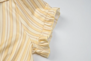Vue macro détaillée du poignet à volants sur un t-shirt vintage français à rayures jaunes