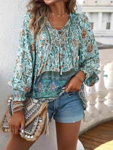 Close-up of bohemian floral blouse with V-neck tie and intricate turquoise print details