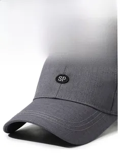 Detail of dark grey baseball cap featuring a round SP embroidered patch and curved brim