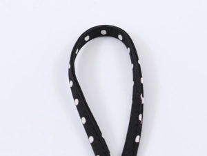 Detail of black fabric strap with white polka dots and high quality texture