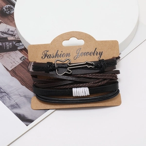 Detail of multi-layer leather bracelets with a metal guitar charm on a display card