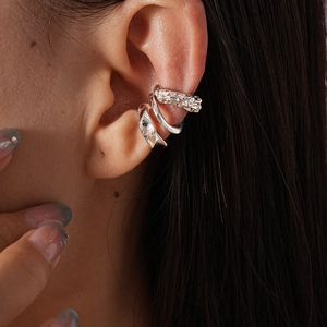 Close-up of silver irregular geometric ear cuffs with hammered texture on ear cartilage