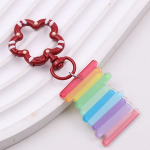 Macro detail of rainbow acrylic butterfly pendant with colorful floral metal lobster clasp