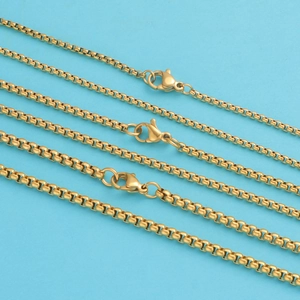Detail of high-gloss gold box chains with lobster clasps on a light blue background