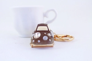 Macro shot of car keychain with sparkling rhinestones and pearls on golden metal ring