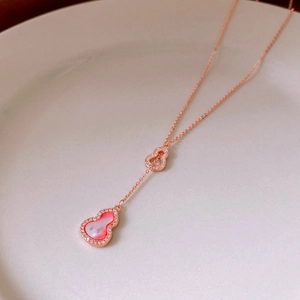 Close-up of rose gold double gourd pendant with pink stones and zircon stones on tray