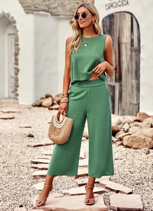 Detail of green two-piece linen set showing sleeveless crop top and wide leg pants