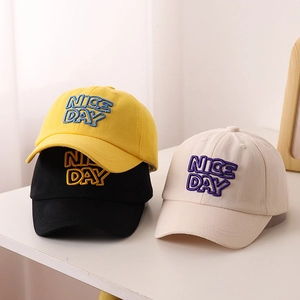 Détail de casquettes en coton jaune, noir et beige avec broderie Nice Day sur le devant