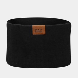 Detail of black ribbed knit infinity scarf with brown leather DAD patch for winter