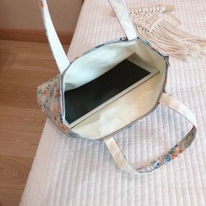 Internal view of floral cotton tote bag showing capacity with a tablet and zipper closure