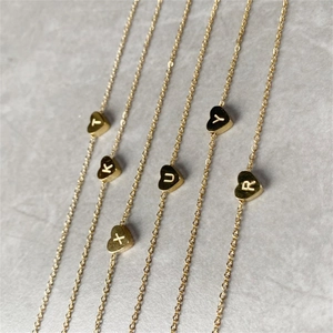 Detailed view of gold DIY heart pendant necklaces featuring engraved initials.