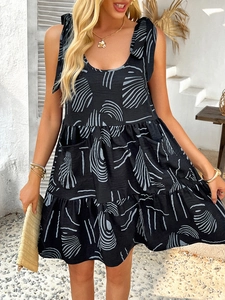Detail view of black sleeveless dress with blue abstract patterns and shoulder tie straps