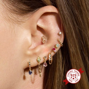 Detail showing 925 sterling silver earrings set with colorful zircons on a model's ear