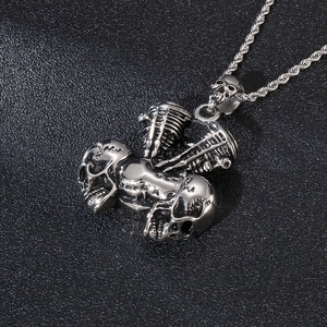 Detailed close-up of a silver gothic skull engine pendant with metallic rope chain