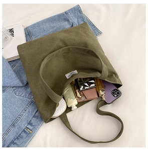 Detail view of large olive green canvas tote bag interior on white bedding background