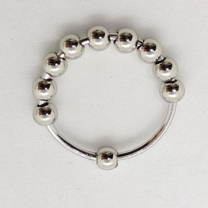 Detailed view of silver rotating beads on stainless steel anxiety ring for stress relief