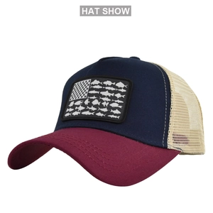 Detail view of American flag fish patch on navy blue and wine red mesh trucker hat