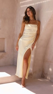 Detail of champagne satin slip dress with elegant side slit and ruched waist design