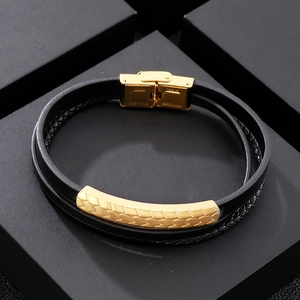 Close-up of black braided leather men's bracelet with golden stainless steel magnetic clasp