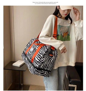 Détail du sac de yoga zébré avec poignées orange et couche d'extension à fermeture éclair