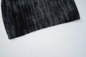 Detail shot of black faux crocodile texture fabric with a velvet finish on the mini dress