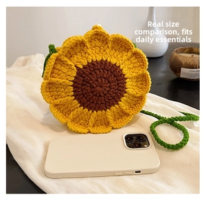 Detail shot of mini sunflower crochet bag showing compact size with a smartphone