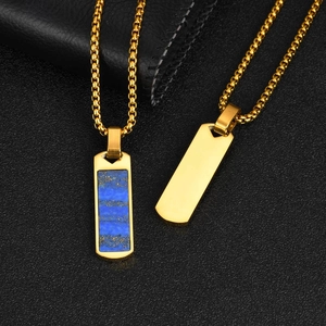 Macro shot of gold rectangle pendant with blue lapis stone on black leather background