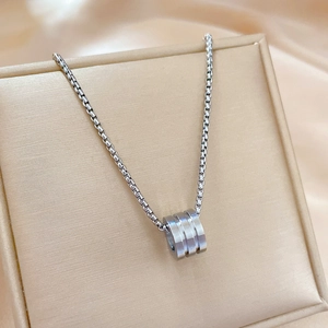 Detailed close-up of a silver titanium steel necklace inside a beige jewelry gift box