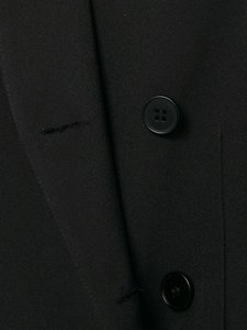 Close-up of black blazer fabric texture featuring fine twill and round four-hole button