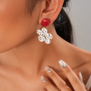 Detailed view of resin flower earring with red square stud and black polka dot petals